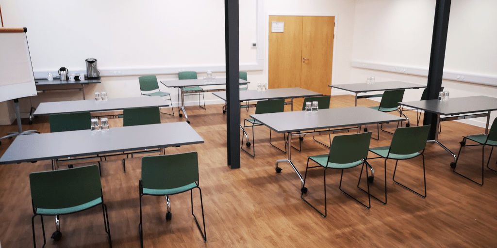 Big Duncan room set in classroom style with tables and green chairs